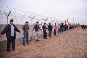 جمعی از دانشجویان در حوالی نیروگاه بوشهر زنجیره انسانی تشکیل می‌دهند
